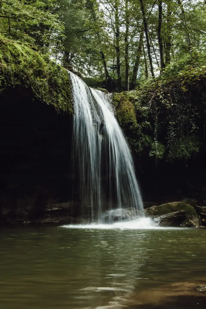 Kleiner Wasserfall in einem Wald.